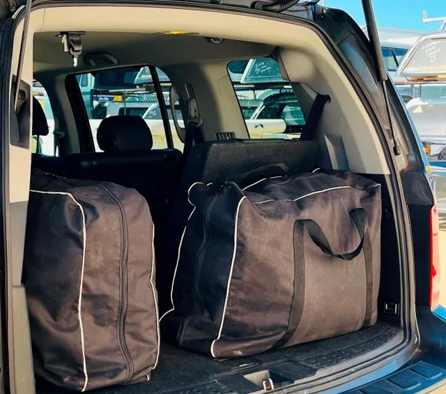 Two Transformer duffle carry bags loaded in the back of an SUV