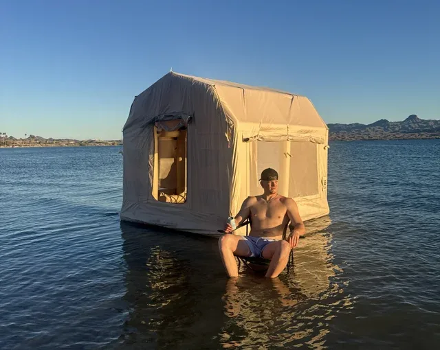 Person relaxing in a chair in shallow water beside a floating Transformer