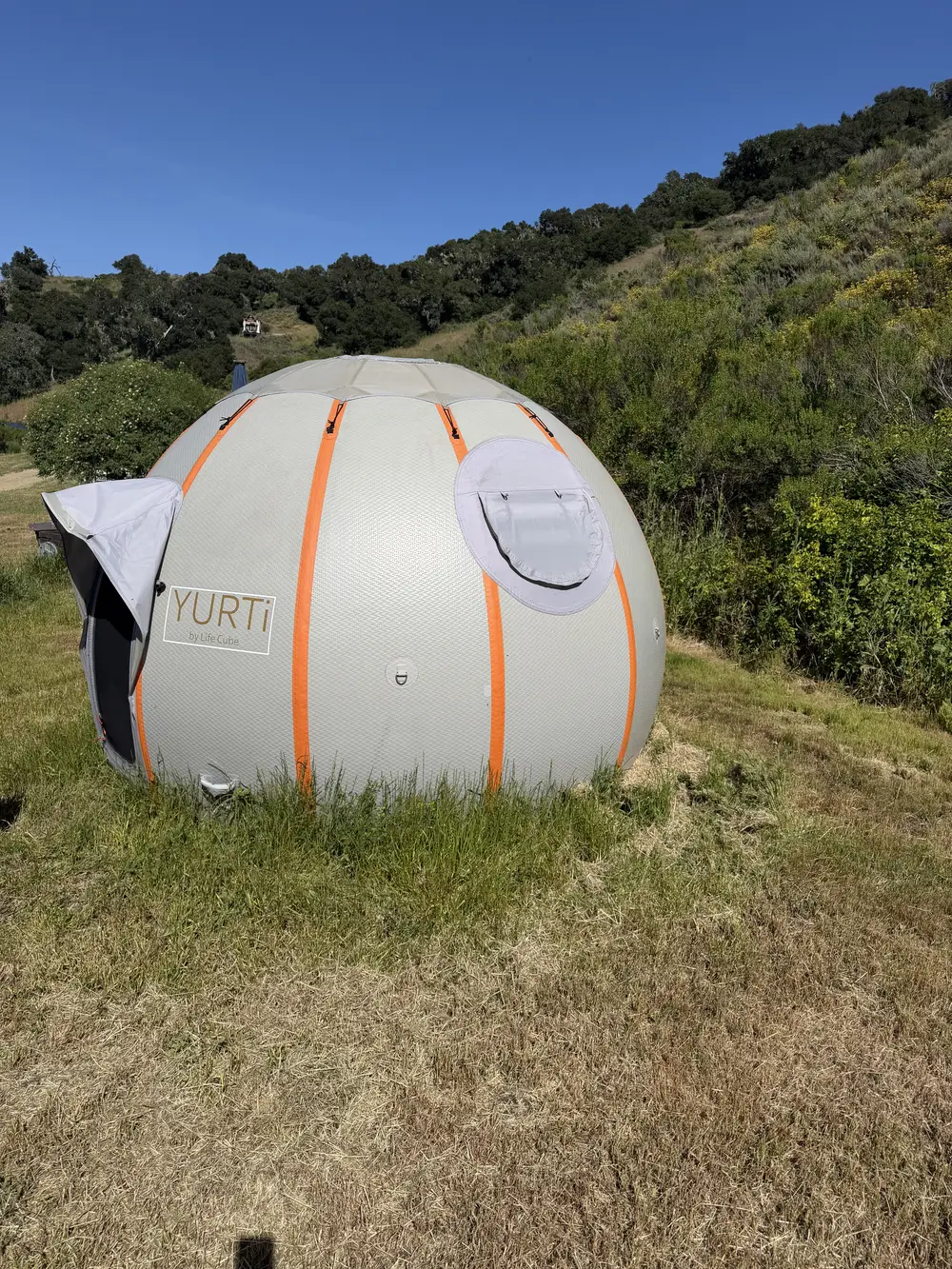 YURTi standing in a grassy field with its window vent open